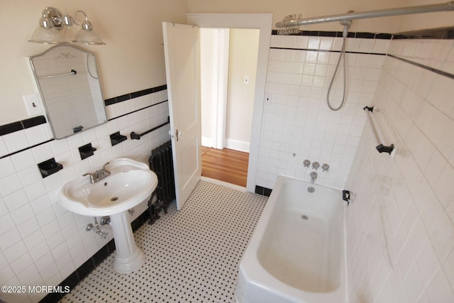 bathroom featuring shower / bath combination, tile walls, and wainscoting