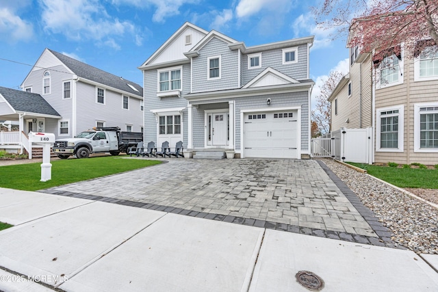 traditional-style home featuring fence, a gate, a front yard, and decorative driveway