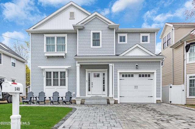 view of front of home with an attached garage, a front yard, decorative driveway, and fence