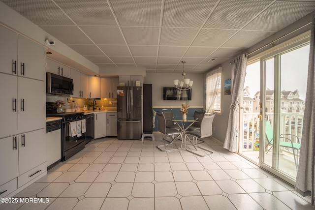 349 Harbor Vw, Forked River, NJ 08731 - kitchen with black appliances, light countertops, a chandelier, light flooring, and white cabinetry