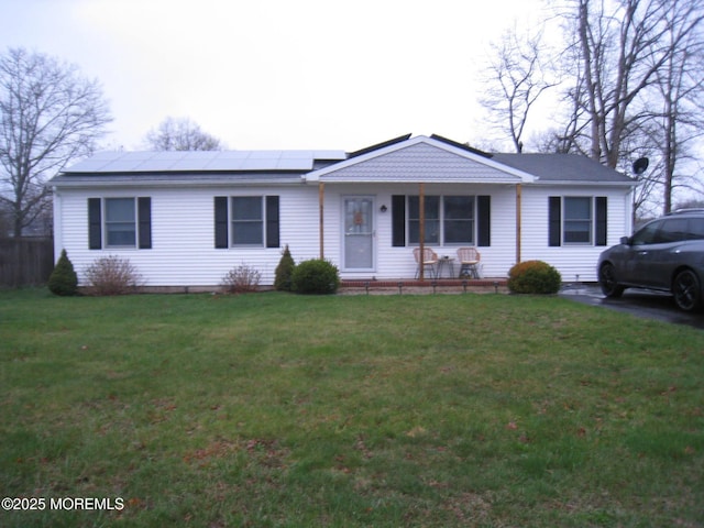 single story home with a front yard and solar panels