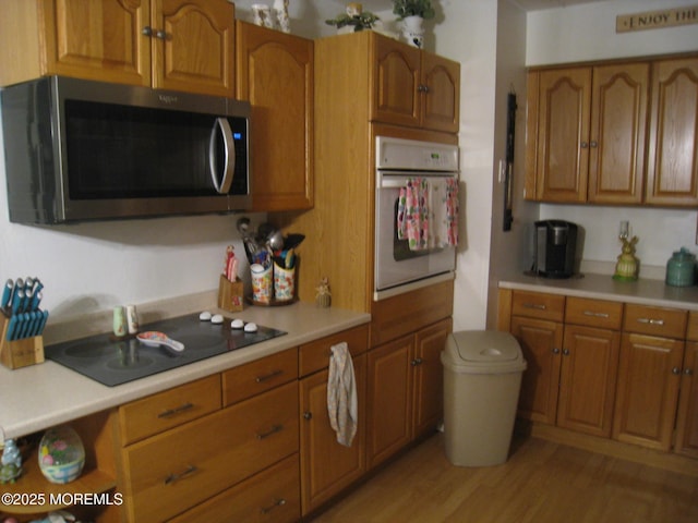 kitchen with brown cabinets, appliances with stainless steel finishes, and light countertops