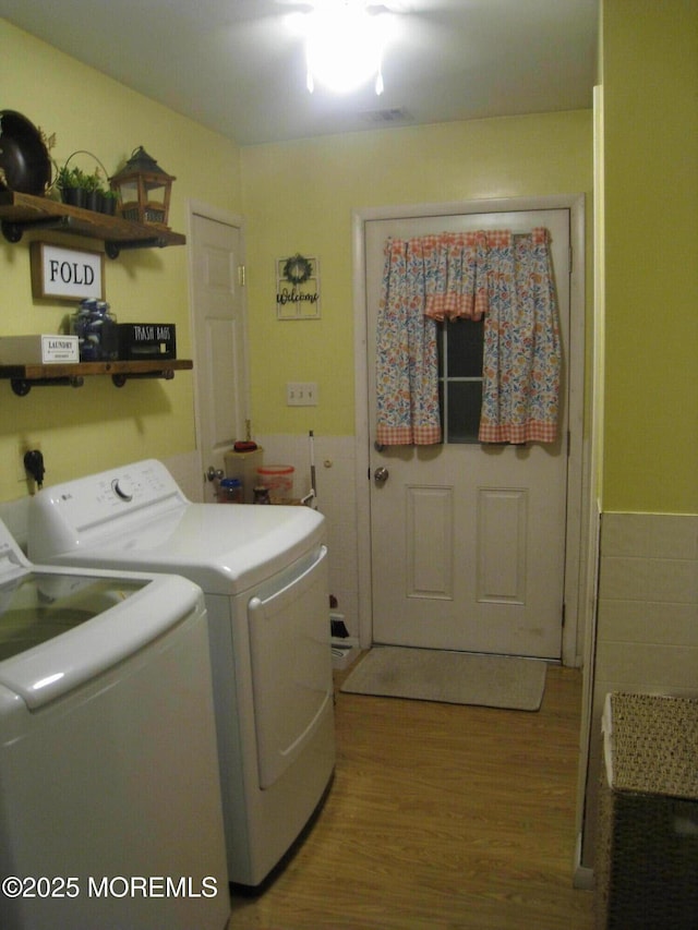 clothes washing area featuring independent washer and dryer, laundry area, and wood finished floors