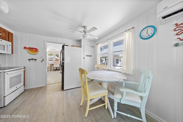 dining area featuring ceiling fan, baseboards, light wood-style floors, and a wall unit AC