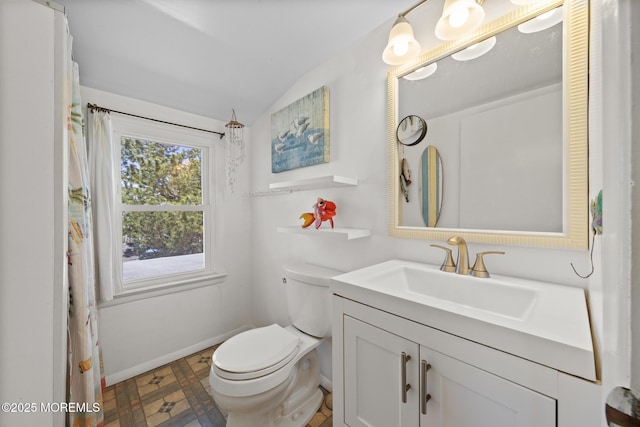 bathroom featuring vanity, baseboards, vaulted ceiling, and toilet