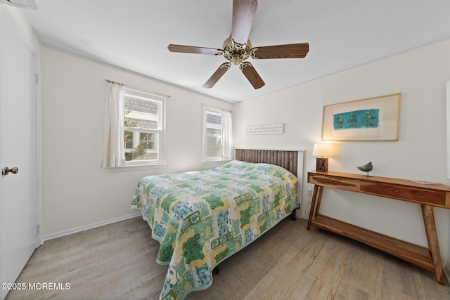 bedroom with wood finished floors, baseboards, and a ceiling fan