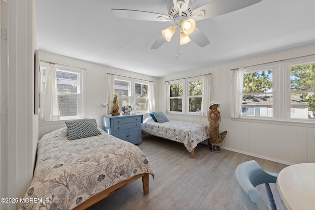 bedroom featuring light wood-style flooring, multiple windows, and a ceiling fan