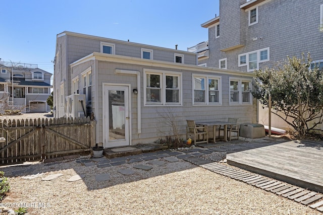 back of house featuring fence, a wooden deck, and a chimney