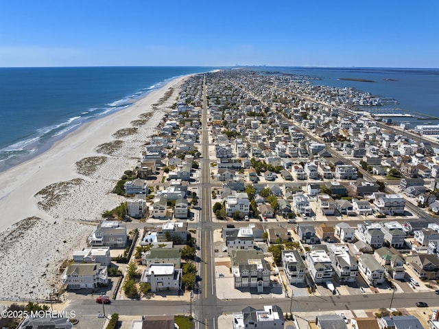birds eye view of property featuring a water view, a beach view, and a residential view