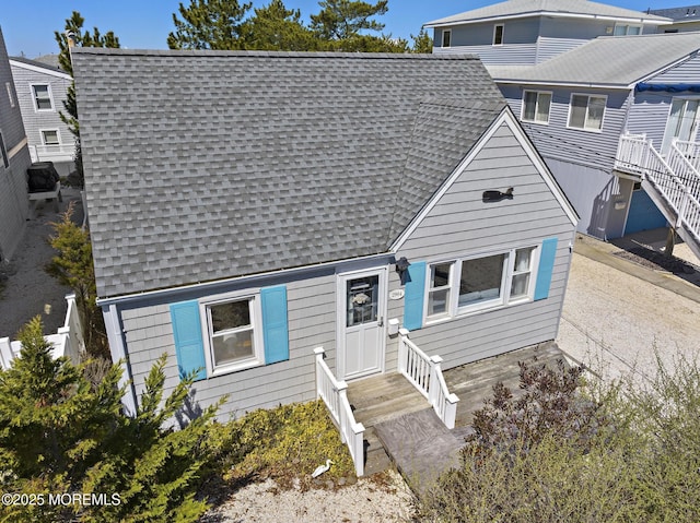 view of front facade featuring entry steps and a shingled roof