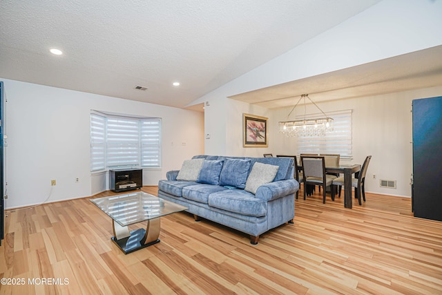 13 Gatley Close Unit 1000, Freehold, NJ 07728 - living room with visible vents, light wood-style flooring, an inviting chandelier, and vaulted ceiling