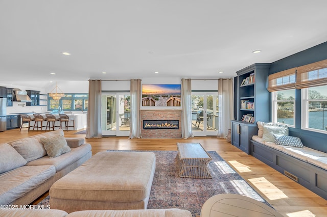 1417 Holmes Ave, Toms River, NJ 08753 - living room with healthy amount of natural light, light wood-type flooring, a glass covered fireplace, and recessed lighting