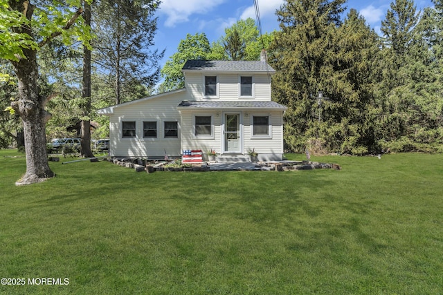 view of front of property with a chimney, roof with shingles, and a front lawn