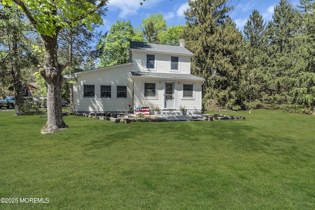 view of front of property with a chimney, roof with shingles, and a front lawn