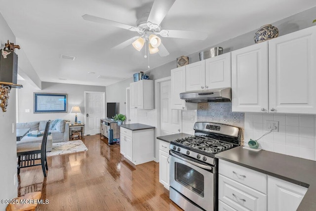 19 Gravelly Point Rd, Highlands, NJ 07732 - kitchen featuring stainless steel range with gas stovetop, under cabinet range hood, dark countertops, a ceiling fan, and light wood finished floors