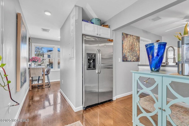 19 Gravelly Point Rd, Highlands, NJ 07732 - kitchen with stainless steel refrigerator with ice dispenser, light wood-type flooring, white cabinets, and baseboards