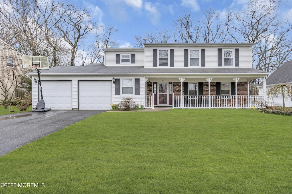 view of front of home with a front yard, an attached garage, covered porch, and aphalt driveway