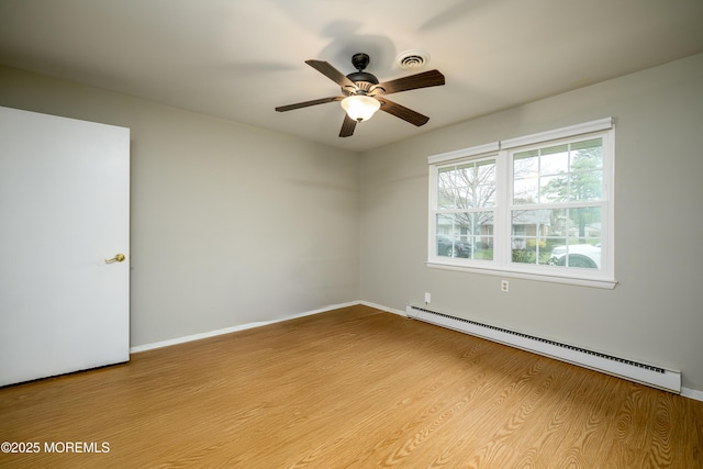 unfurnished room with baseboards, visible vents, wood finished floors, ceiling fan, and a baseboard radiator