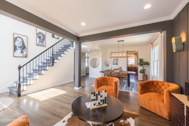 living area with crown molding, baseboards, stairs, and wood finished floors