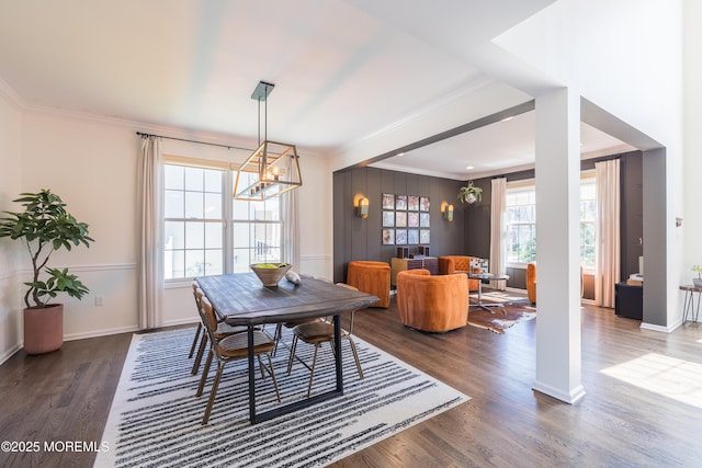 dining area with baseboards, ornamental molding, a notable chandelier, and dark wood-style floors