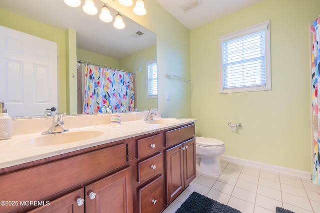 bathroom featuring double vanity, baseboards, visible vents, and a sink