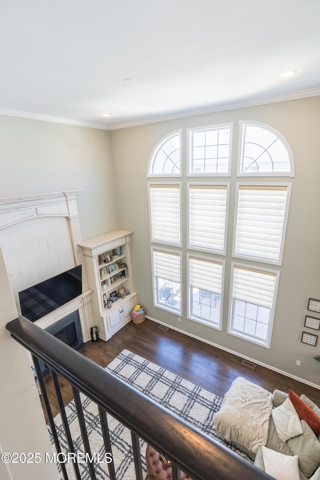 living area featuring visible vents, ornamental molding, and a healthy amount of sunlight