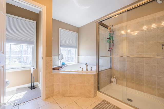 full bathroom featuring tile patterned floors, a shower stall, a bath, and a wealth of natural light
