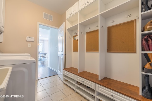 mudroom with washer and dryer, visible vents, and light tile patterned floors
