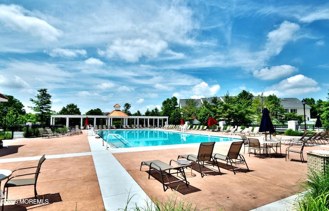 community pool with a patio and fence