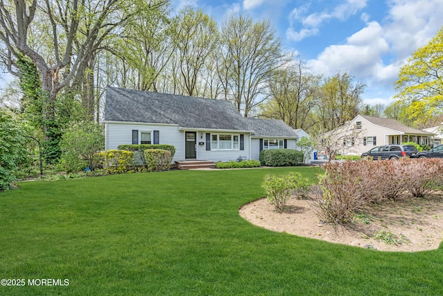 ranch-style home featuring a front lawn and a shingled roof