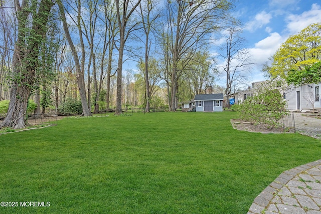 view of green lawn with an outdoor structure