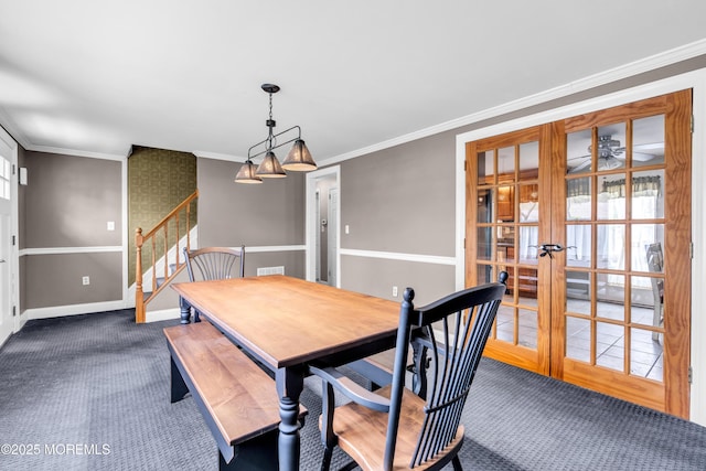 dining area with crown molding, dark colored carpet, baseboards, french doors, and stairway