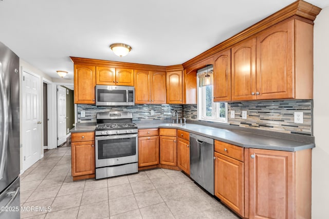 kitchen featuring stainless steel appliances, decorative backsplash, and a sink