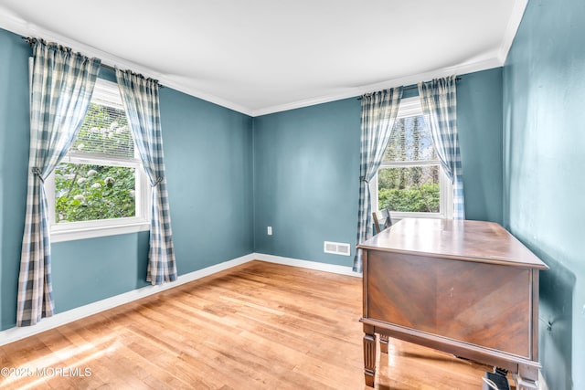 home office featuring wood finished floors, healthy amount of natural light, baseboards, and ornamental molding