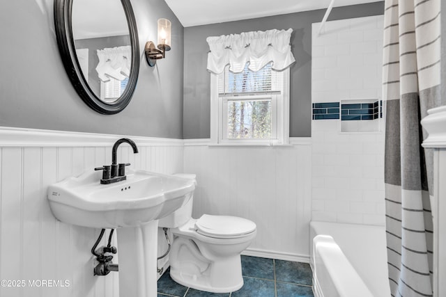 full bathroom with wainscoting, toilet, tile patterned floors, and shower / bath combo