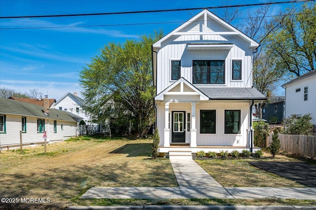 modern inspired farmhouse featuring a porch, fence, and a front yard