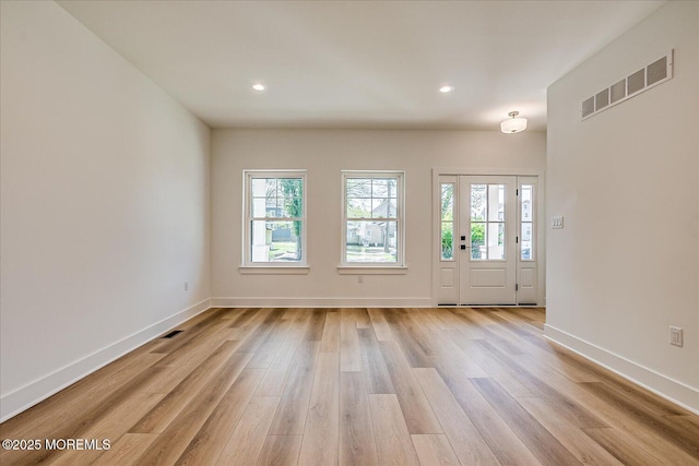 interior space with visible vents, a wealth of natural light, and light wood-style flooring