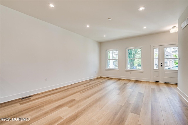unfurnished room featuring recessed lighting, baseboards, visible vents, and light wood-type flooring