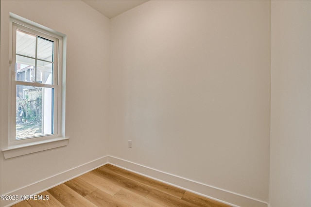 unfurnished room with baseboards and light wood-style flooring