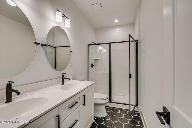 bathroom featuring toilet, tile patterned floors, a sink, and a stall shower