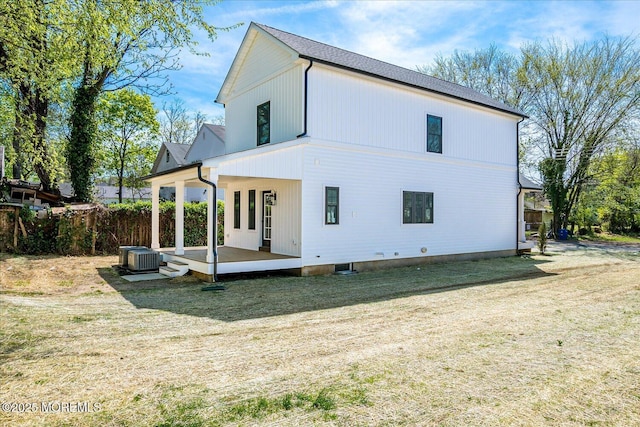 back of house featuring a lawn, central AC, and a wooden deck