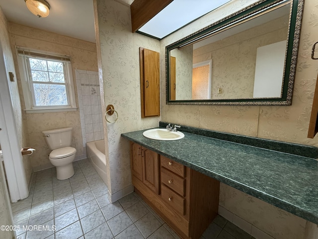 bathroom featuring toilet, tile patterned floors, vanity, and a washtub