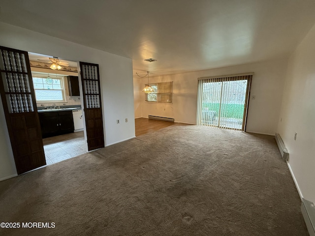 interior space with a baseboard heating unit, carpet, visible vents, and a baseboard radiator