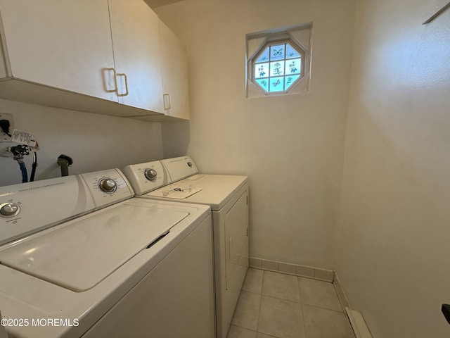 laundry area featuring light tile patterned floors, washer and clothes dryer, baseboards, and cabinet space