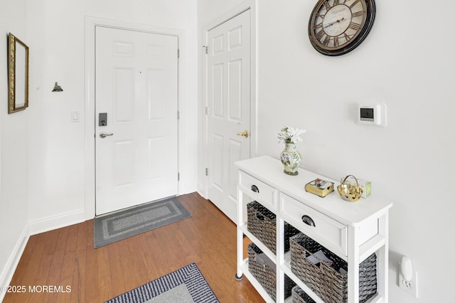 doorway to outside with baseboards and dark wood finished floors