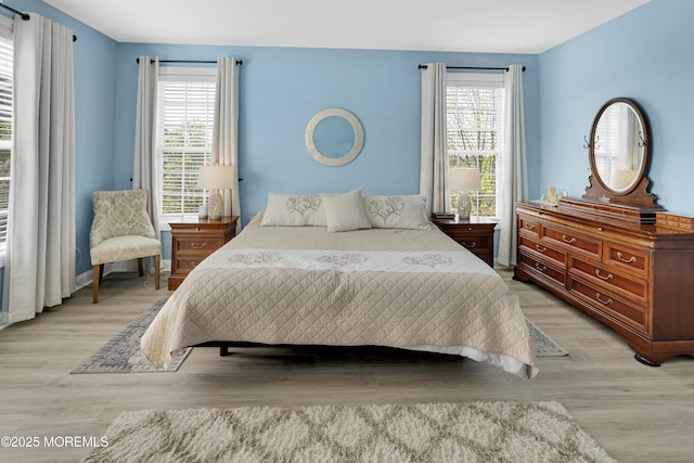 bedroom with light wood-type flooring and multiple windows