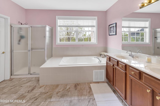 bathroom with a sink, a wealth of natural light, a shower stall, and visible vents