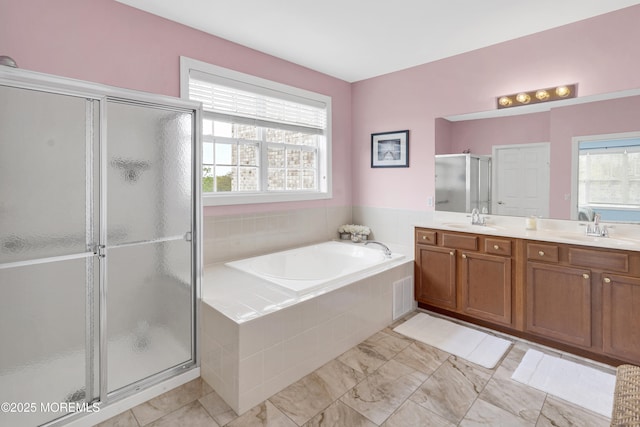 bathroom featuring double vanity, a sink, a bath, and a stall shower