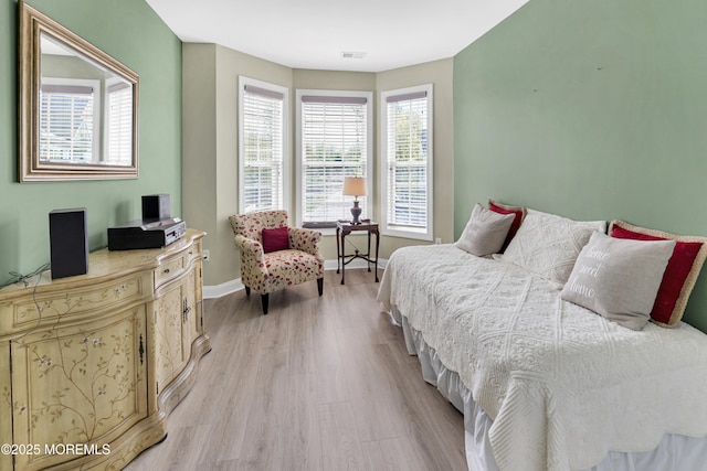 bedroom with baseboards, visible vents, and light wood-style floors
