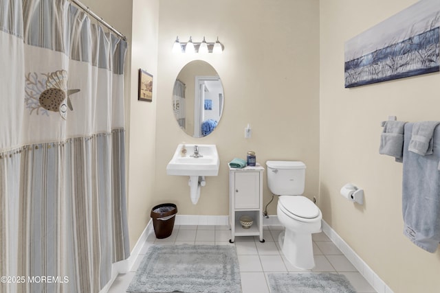 bathroom featuring tile patterned flooring, a sink, a shower with shower curtain, and toilet